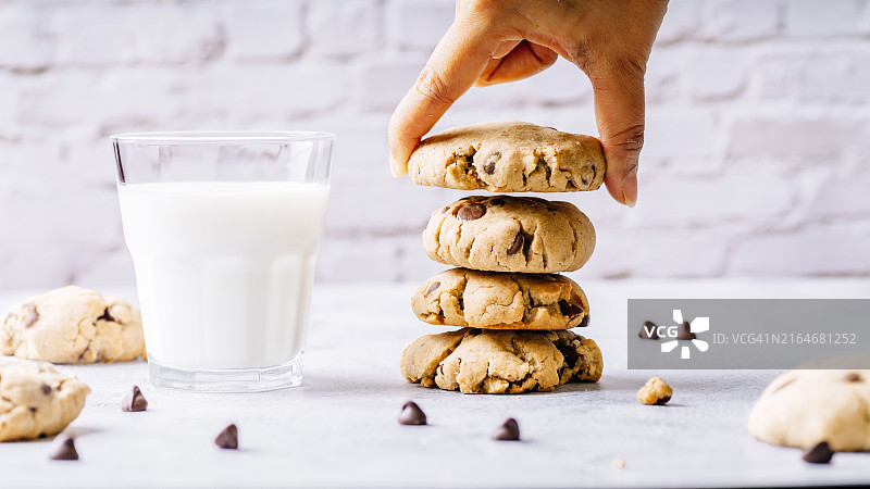 大理石背景上的巧克力曲奇和一杯牛奶图片素材