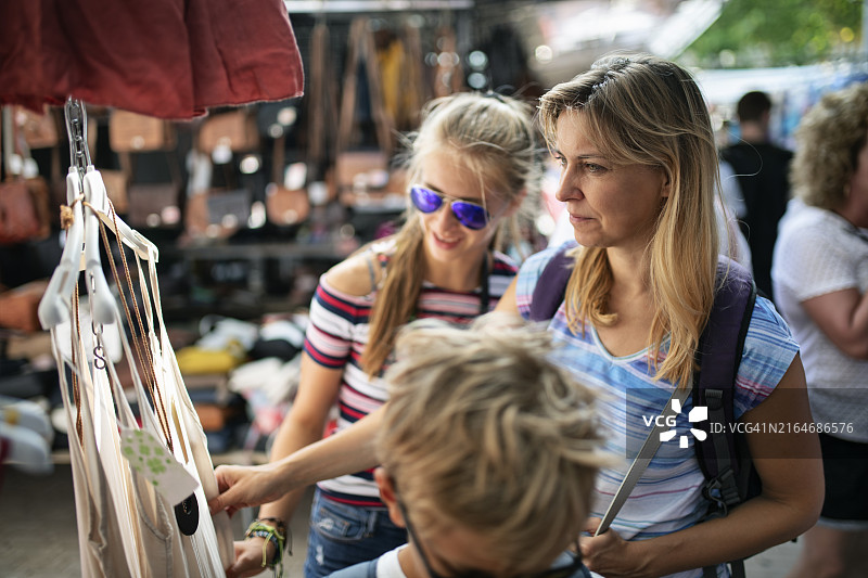 在西班牙农贸市场浏览服装的一家人图片素材