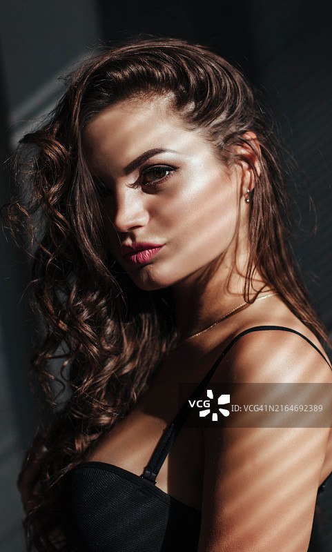 特写的诱人的脸的黑发美女与美丽的化妆和嘴唇，豪华的发型和轻浮的样子图片素材
