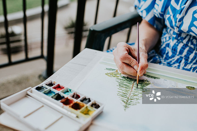 女子在阳台上绘画树木风景图片素材