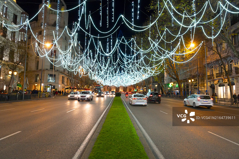 绚丽的夜间城市景观：马德里阿尔卡拉大街的圣诞灯饰和阿尔卡拉门图片素材