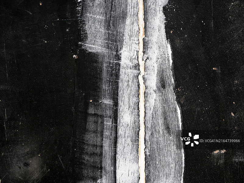 巴黎建筑工地：黑色木板间的石膏接缝，粗糙纹理，自然光图片素材