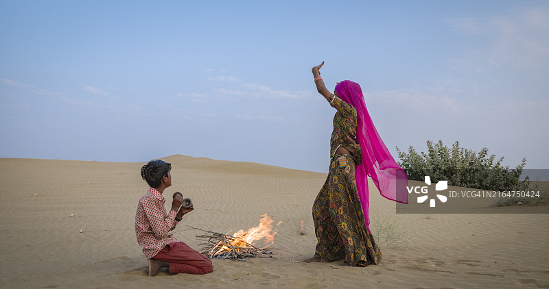 快乐的印度女孩在沙丘上跳舞，印度沙漠村庄图片素材
