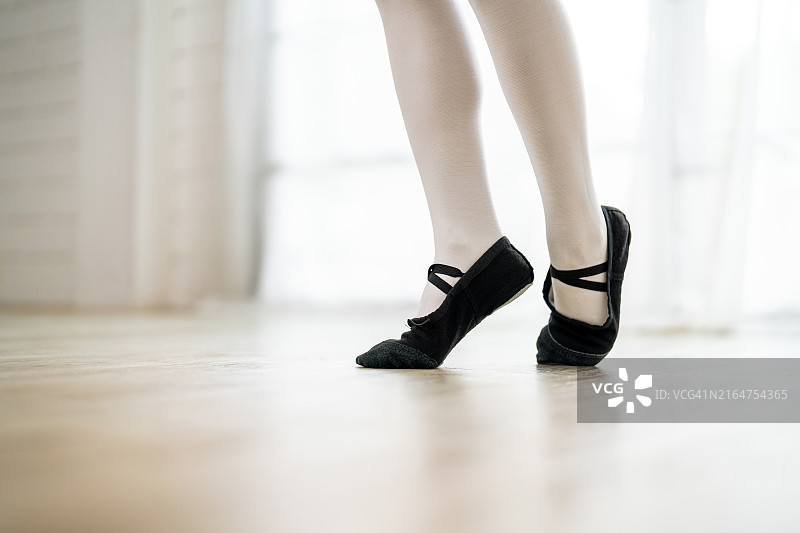 芭蕾舞女演员在家里练习芭蕾舞旋转和跳跃的脚部特写图片素材