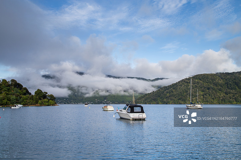 马尔堡夏洛特女王峡湾晨曦中的系泊船与海雾山脉图片素材