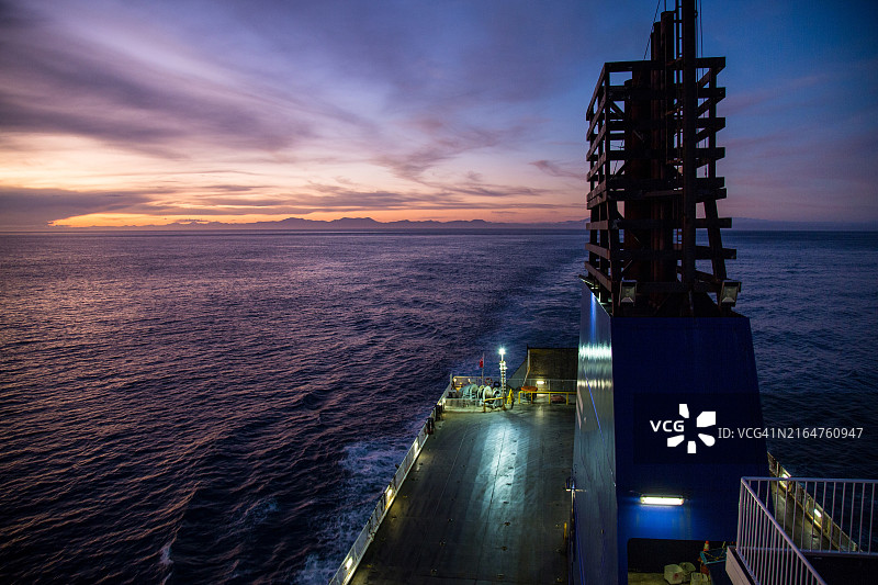 日落时分库克海峡渡轮顶层甲板的船尾景观，远处是新西兰马尔堡南岛图片素材