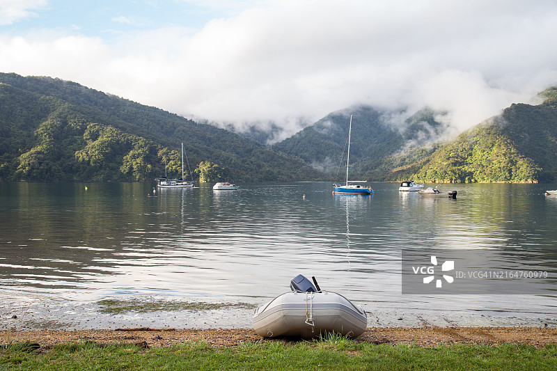 马尔堡莫莫朗吉湾平静水面上的系泊船只，背景是海雾和山脉图片素材