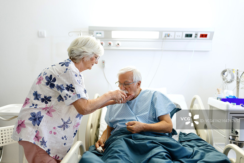 老年妇女在医院给生病的丈夫递水图片素材