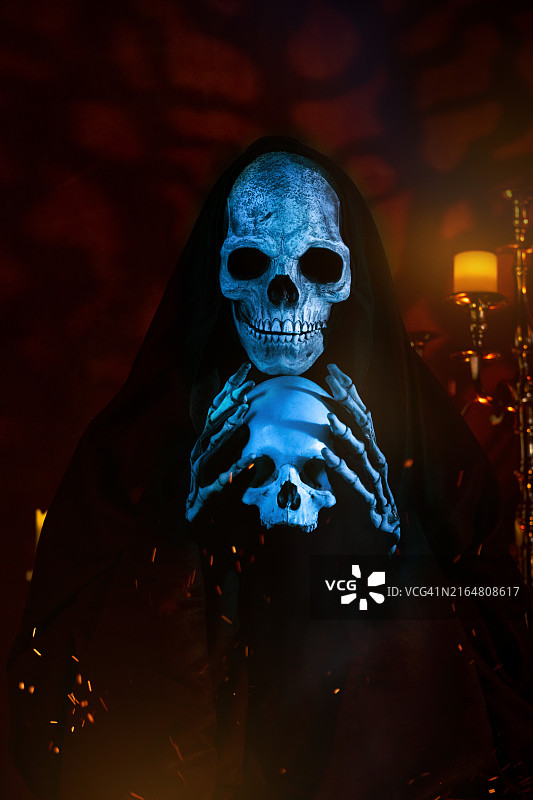 手持人类头骨，直视镜头的恐怖死神图片素材