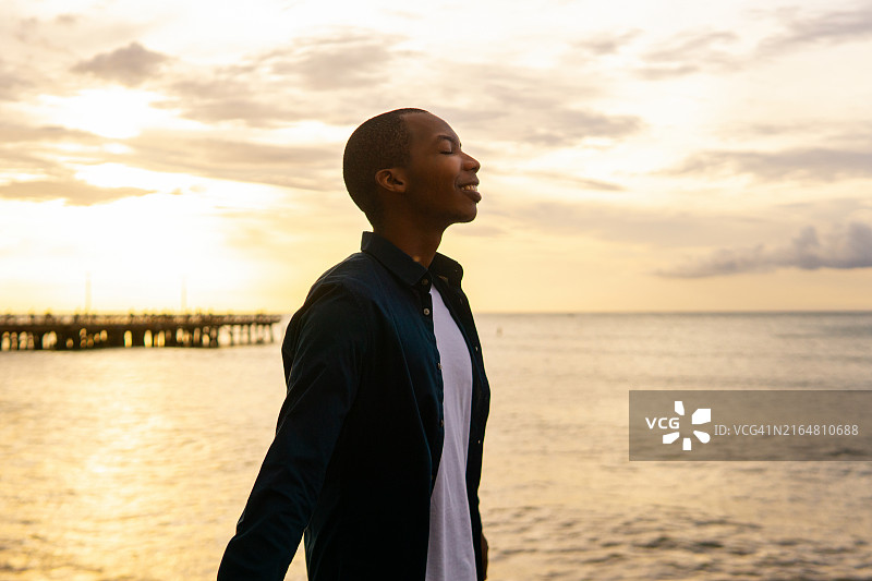 在海滩呼吸新鲜空气的休闲黑人男子图片素材