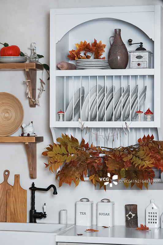 浅色系乡村风格的秋季厨房装饰，有树叶、南瓜和蜡烛图片素材