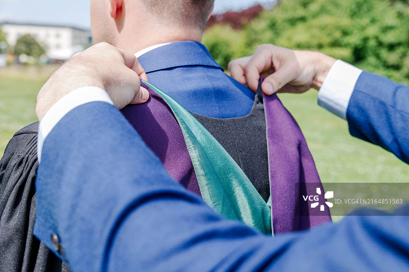 整理毕业礼服帽兜的手图片素材