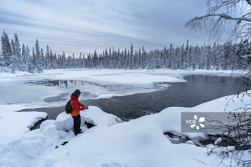 在芬兰冰冻的湖面上钓鱼的游客图片素材