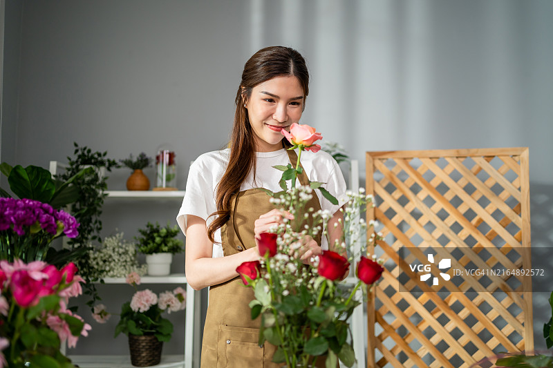 花店里正在制作花束的亚洲年轻女花艺师图片素材