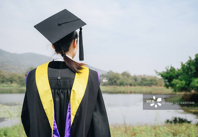 毕业典礼上戴着毕业帽的年轻女学生背影图片素材