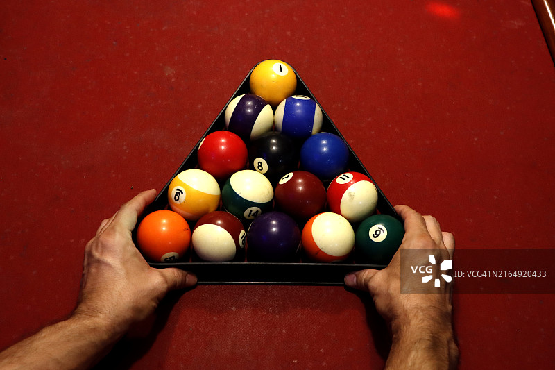 摆一局新台球的人：红色桌子上的三角球框和台球图片素材