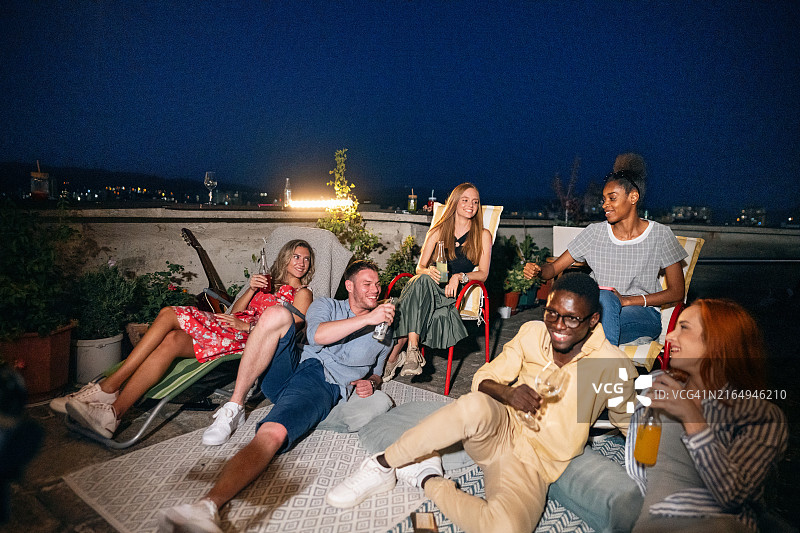 多种族男女朋友在屋顶上进行电影之夜图片素材