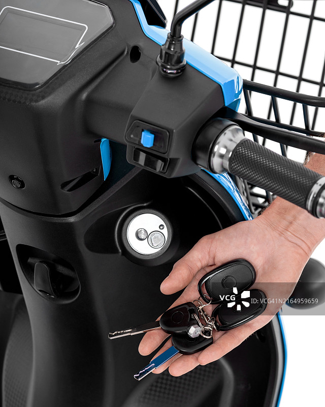 男人手中背景为自行车的滑板车钥匙图片素材