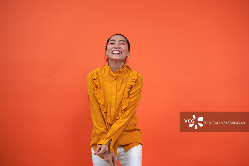 穿着橙色长袖衬衫的亚洲女演员图片素材