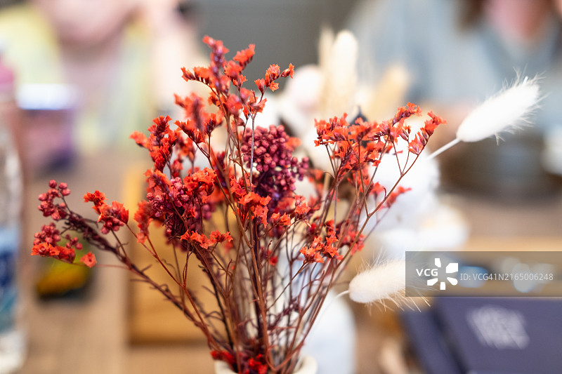 咖啡馆餐桌花瓶中的红色干花图片素材