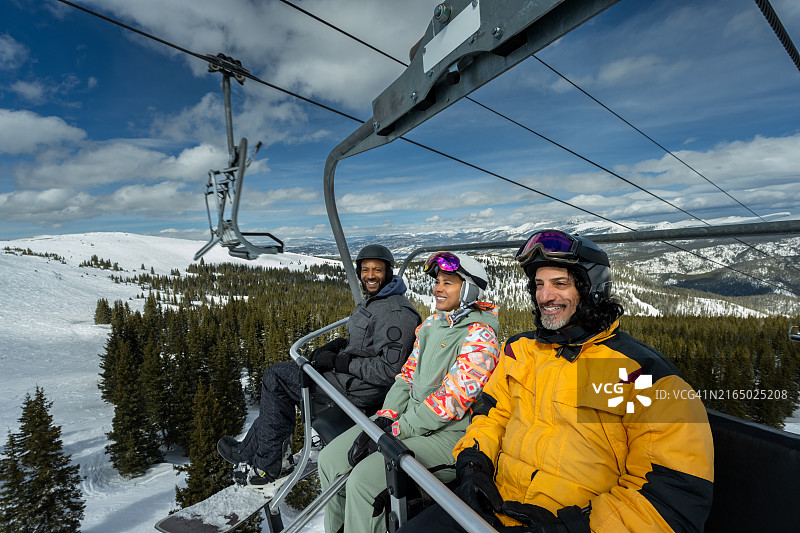 两个男人和一个女人从滑雪缆车上眺望冬季景色图片素材