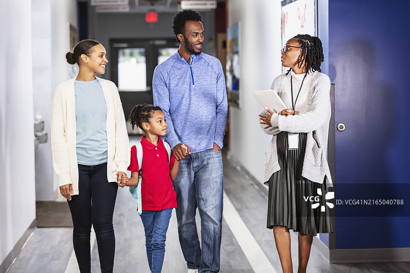 父母送女儿上学，走廊里有老师图片素材