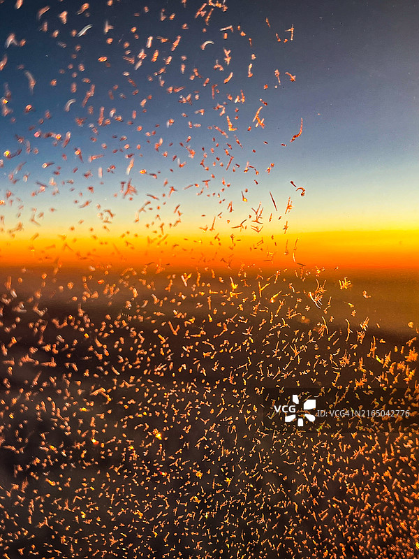 日落时飞机窗户上的冰图片素材