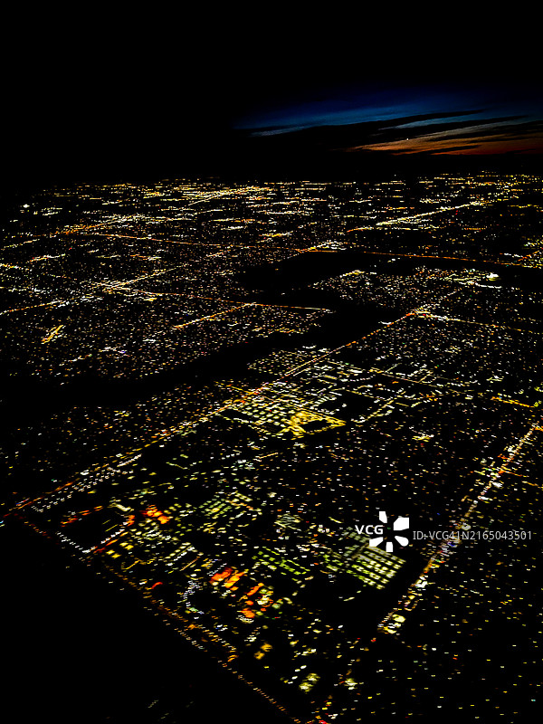 从跨洲夜间航班俯瞰灯火通明的城市图片素材