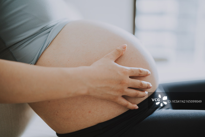 孕妇抚摸腹部特写图片素材