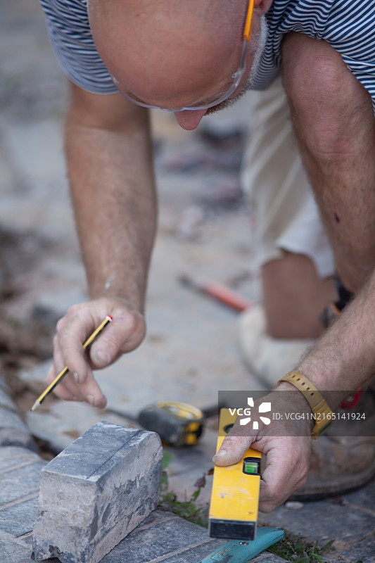建筑工人建造蓝色砖砌路缘图片素材
