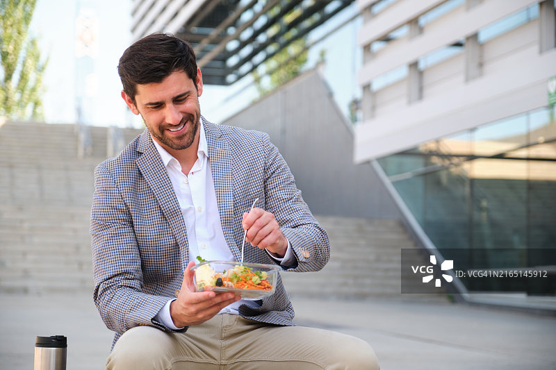 快乐的商人在办公室外吃健康沙拉午餐图片素材