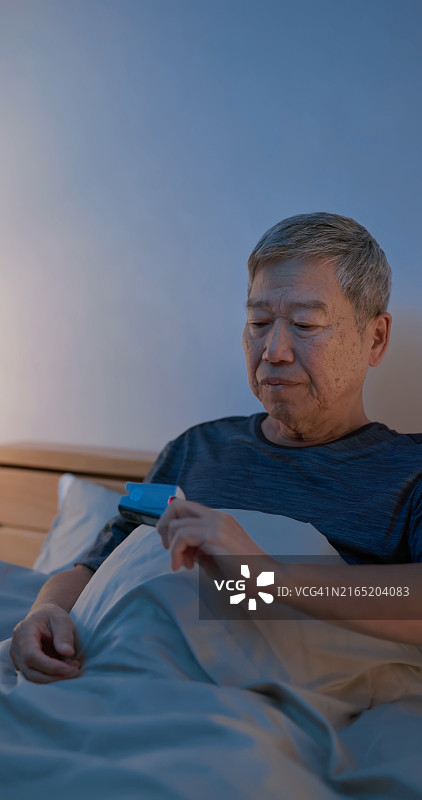 老人看脉搏血氧仪图片素材