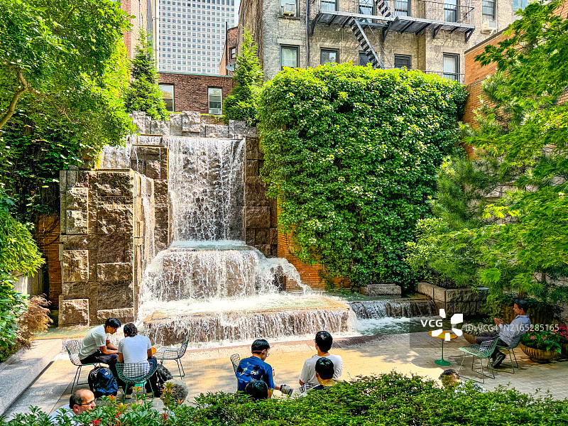 人们在纽约市中城东区格林acre公园瀑布附近放松身心图片素材