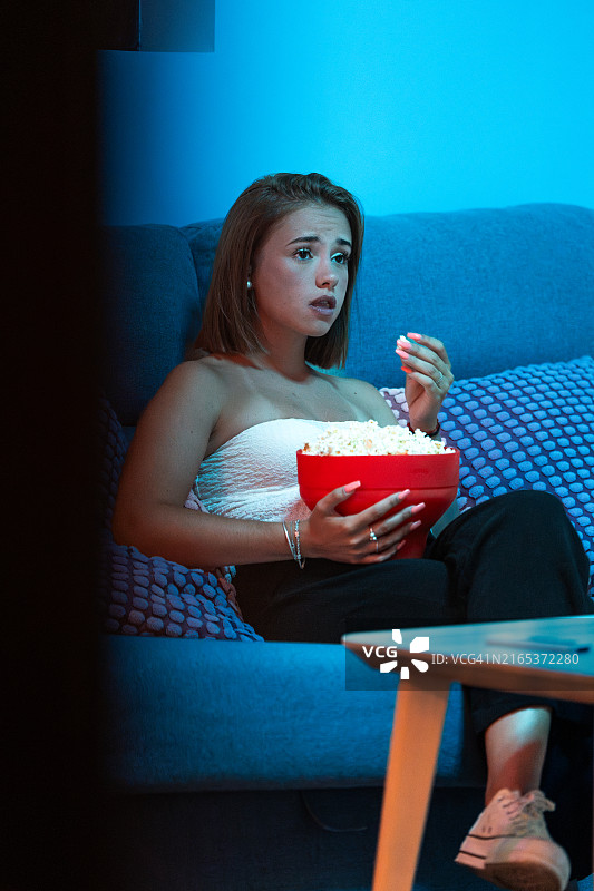 年轻女子在家享受爆米花电影之夜图片素材