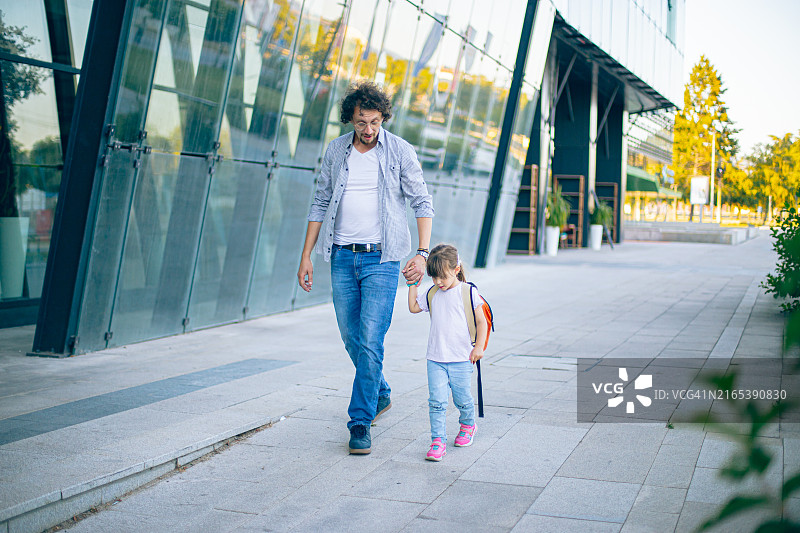 可爱的小女学生和父亲一起放学回家图片素材