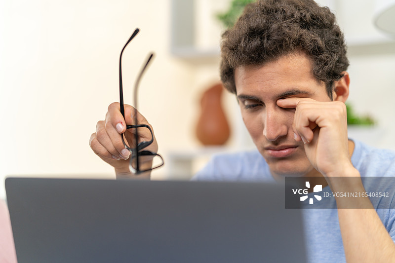 厌倦了在笔记本电脑上工作的男人图片素材