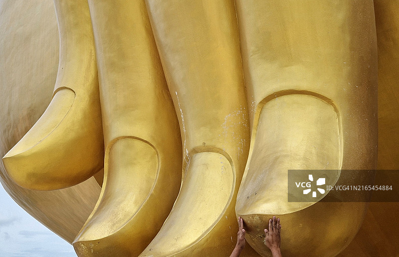 触摸泰国安通府芒寺佛像的手指图片素材