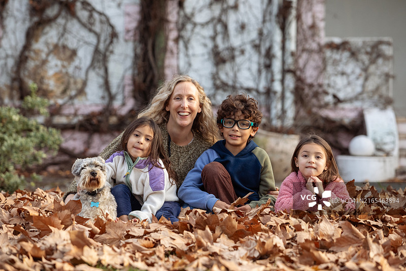 秋天户外，母亲和三个孩子玩耍的温馨 портрет图片素材