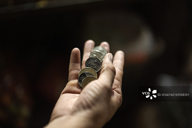 手持菲律宾硬币的人图片素材