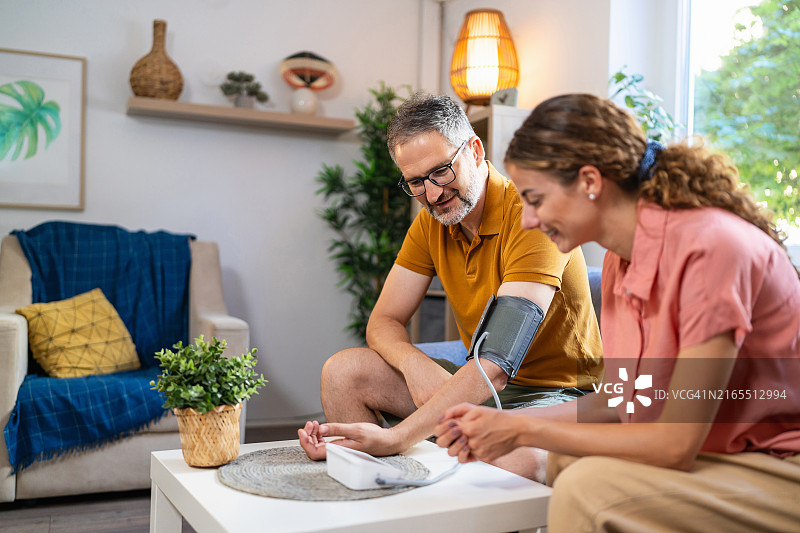 妻子帮助丈夫测量血压图片素材