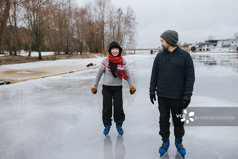 快乐的日本夫妇在结冰的湖面上滑冰图片素材