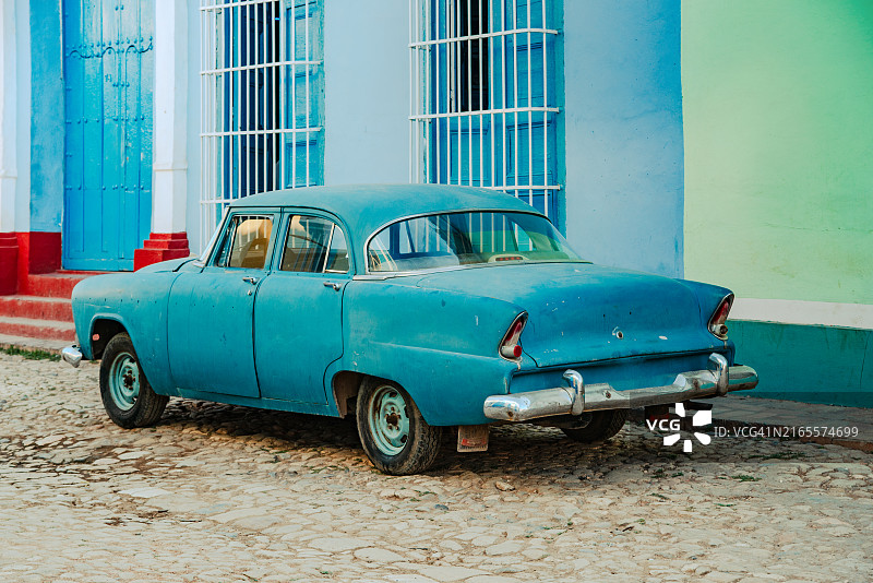 停在古巴特立尼达历史街区的复古蓝色汽车图片素材