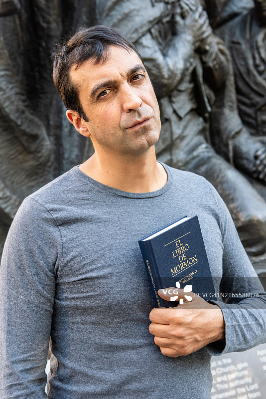 在盐湖城摩门教圣殿附近手持西班牙语《摩门经》的西班牙裔男子图片素材
