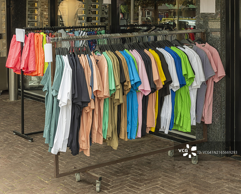 服装店前衣架上悬挂的各色T恤图片素材