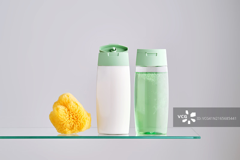 浴室玻璃架子上的洗发水和护发素图片素材