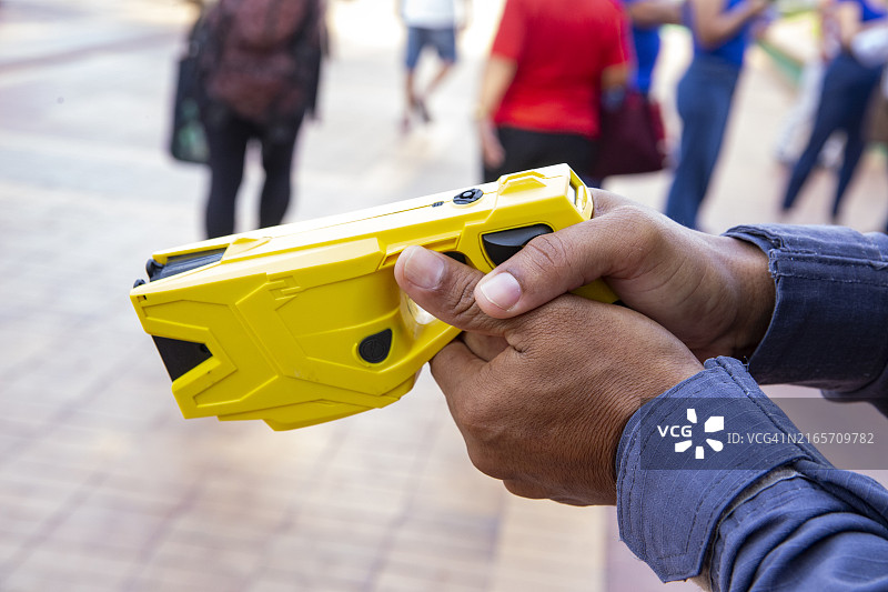 警察手持黄色泰瑟枪（低致命性弹药）细节图片素材