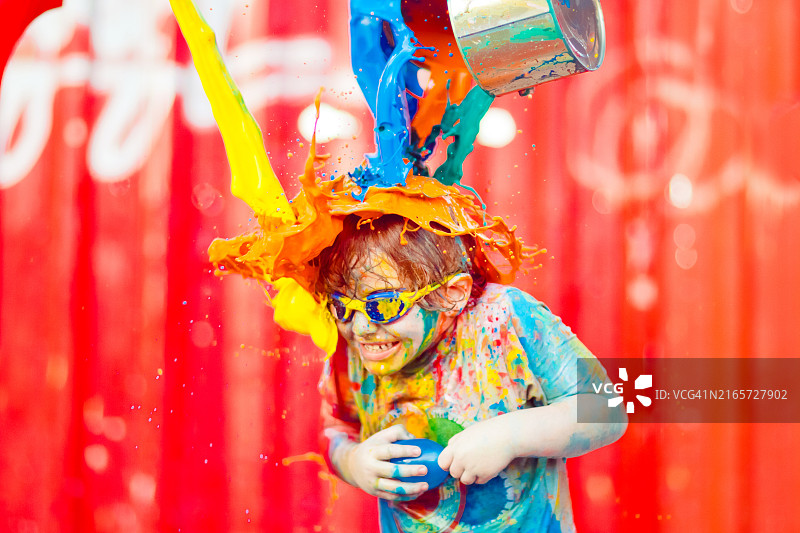 在加拿大不列颠哥伦比亚省维多利亚市，一个男孩在洒红节期间穿着服装并涂抹颜料的肖像图片素材