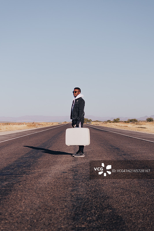 商人手提白色手提箱站在美国的道路上图片素材