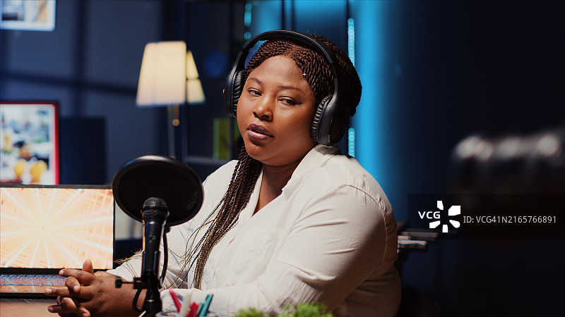 演示者向播客观众致意，用专业相机拍摄图片素材