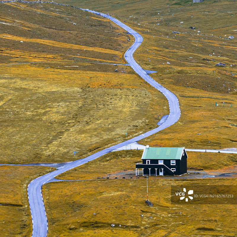 空旷的道路，路过一栋孤独的传统房屋图片素材